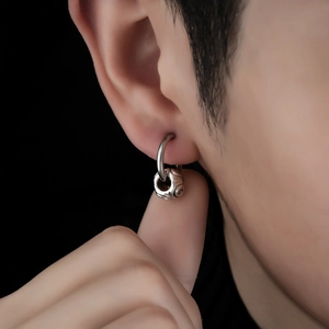 Boucle d'oreille vintage unisexe en acier avec pendentif texturé sur fond noir