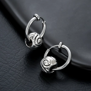 Créoles vintage en acier argenté avec perles spirales sur fond de cuir noir élégant
