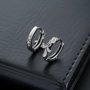 Retro silver cross hoop earrings in Gothic style on black leather background