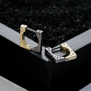 U-shaped earrings in gold and silver finish with vintage patterns on a black box