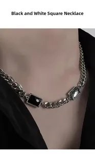 Detail view of silver cuban chain necklace with emerald-cut black and gray gemstones
