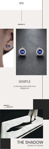 Close-up of blue zircon stud earrings with sparkling white pavé halo in silver