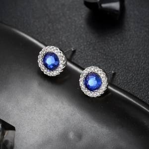 Blue zircon halo stud earrings with silver metal and transparent side stones