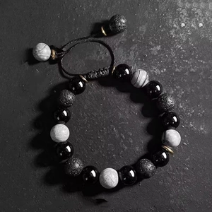 Adjustable men's beaded bracelet featuring obsidian and lava stones on a stone background