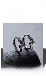 Detail of vintage gothic hoop earrings with cross relief pattern in titanium steel
