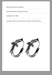 Detailed macro view of vintage silver cross earrings with gothic feather engraving for men