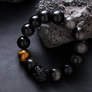 Men's tiger eye stone bead bracelet with black obsidian beads and carved beast charm