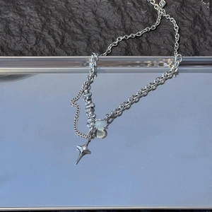 Detail of silver titanium star pendant with opal bead on double layer metal chain