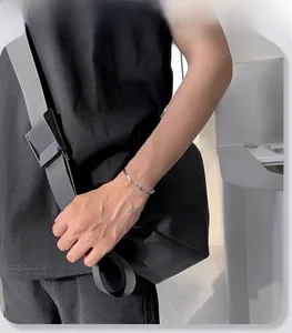 Dettaglio di un bracciale minimalista a maglie romboidali color argento sul polso