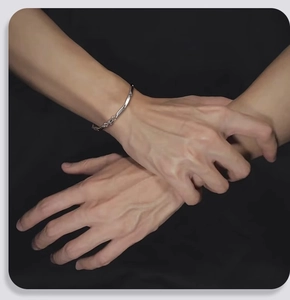 Primo piano di un bracciale geometrico a torsione in argento con finitura lucida