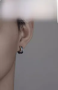 Close-up of titanium steel ear cuff with Greek meander pattern worn by male model