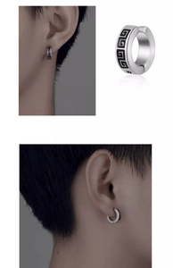 Macro view of titanium steel clip earrings with black Greek key geometric pattern