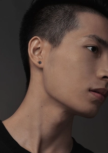 Gros plan d'une boucle d'oreille tendance pour homme avec zircon carré noir et griffes en argent