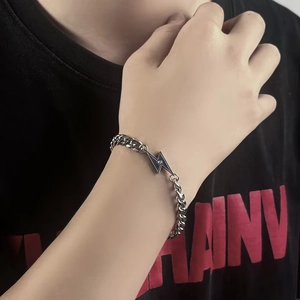 Pulsera cubana de acero de titanio plateada con colgante de rayo en esmalte negro y circón