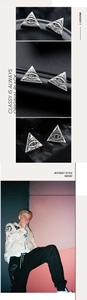 Macro shot of silver triangle stud earrings with Eye of Horus relief and red crystal stone