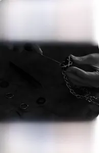 Detailed view of the handcrafted black heart pendant being set onto a silver metal chain