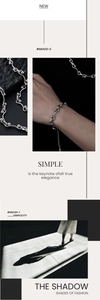Close-up of a silver wavy bead bracelet with interlocking links on a model's wrist