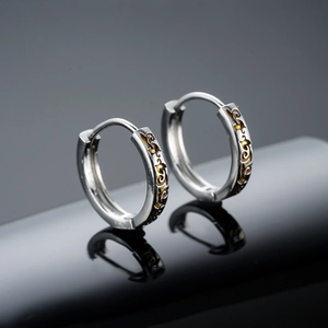Orecchini vintage in argento con motivo a vite dorata su superficie nera