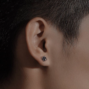 Boucle d'oreille trèfle pour homme avec pierre noire et design vortex argenté sur modèle