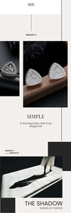 Detail view of geometric triangle stud earrings with pave crystals on wooden props