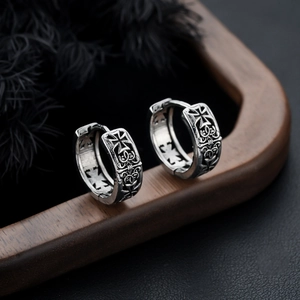 Retro silver hoop earrings with gothic Maltese cross engravings on dark wooden texture