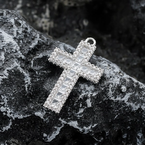 Vue macro d'un pendentif croix en argent serti de zircons sur pierre sombre