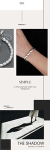 Macro view of minimalist silver stainless steel chain bracelet with oval links