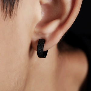 Men's titanium steel clip-on earring in matte black finish with glitter texture on ear