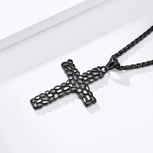 Detail of matte black cross pendant with textured pebble finish on a metal twist chain