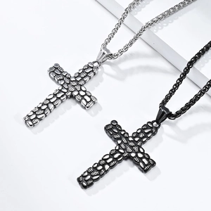 Close-up of silver and black pebble textured stainless steel cross pendants with chain