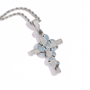 Détail du pendentif croix serpent en argent avec cristaux et chaîne torsadée épaisse