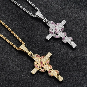 Détail de pendentifs croix serpent en or et argent avec zircons sur chaînes de corde