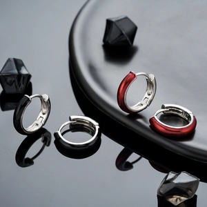 Minimalist enamel hoop earrings in black and dark red colors on a reflective background