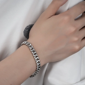 Polished silver Cuban link bracelet on wrist showing modern industrial metal texture