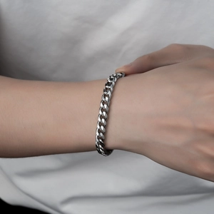Close-up of minimalist silver titanium steel cuban link bracelet on male wrist