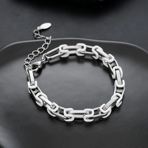 Dettaglio bracciale a maglie in acciaio al titanio con inserti bianchi e chiusura a moschettone