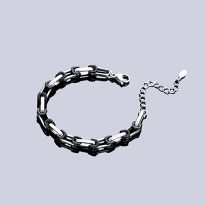 Dettaglio del bracciale in acciaio al titanio con maglie industriali e chiusura a moschettone