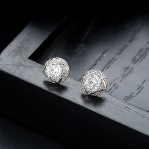 Vue macro de boucles d'oreilles trèfle en argent avec zircons brillants et détails ciselés