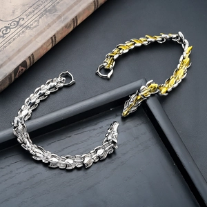 Close-up of vintage dragon head bracelets with intricate scale links in silver and gold