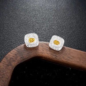 Macro shot of silver and gold vintage earrings featuring an engraved Fu symbol