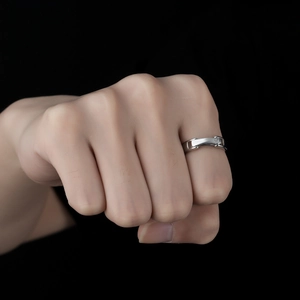 Minimalist silver couple ring with diamond inlay and creative buckle design on a fist