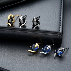 Set de boucles d'oreilles serpent en or argent et noir avec pierres ovales sur fond noir