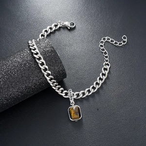 Macro shot of silver tiger eye stone bracelet featuring a Lucky engraved charm