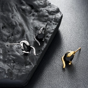 Vue détaillée de boucles d'oreilles serpent avec pierres noires en argent et doré
