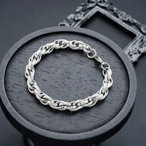 Sleek textured titanium steel link bracelet on a black display tray with lobster clasp