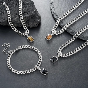 Tiger eye and black stone pendant necklaces with silver curb chains and Lucky charms