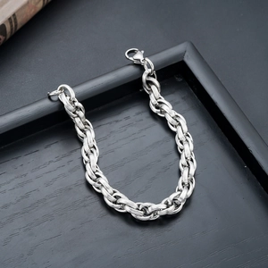 Macro shot of silver titanium steel chain bracelet with textured links and lobster clasp