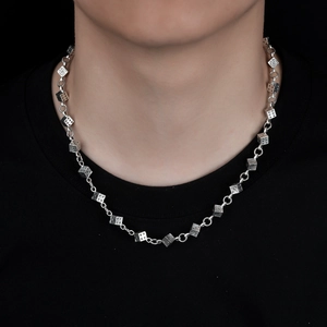 Vue détaillée du collier en métal avec des dés et des gravures gothiques punk