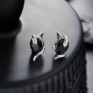 Gros plan détaillé des boucles d'oreilles serpent gothiques avec pierres noires facettées