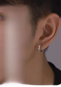Détail de boucles d'oreilles créoles argentées avec motif nœud sur un mannequin homme